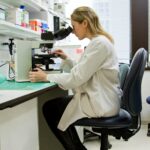 researcher looking into a microscope